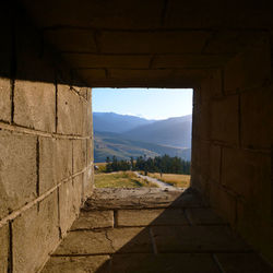 Scenic view of mountains against sky seen through window