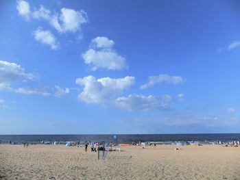 People on beach against blue sky