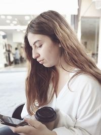 Portrait of beautiful young woman sitting outdoors