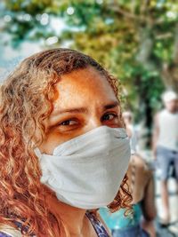 Close-up portrait of woman wearing mask standing outdoors