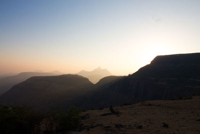 Scenic view of mountains against clear sky during sunset