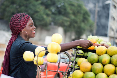 Portrait of young woman holding fruits