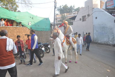 Group of people walking on road in city