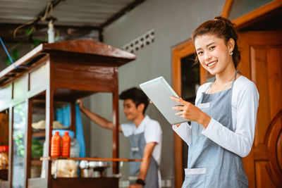 Portrait of smiling young woman using digital tablet