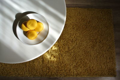 Directly above shot of yellow macaroons on plate at home