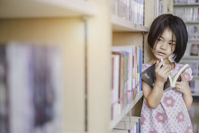 Full length of a girl holding book