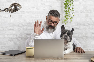 Freelance man working from home with his dog. entering a meeting with a cute dog person