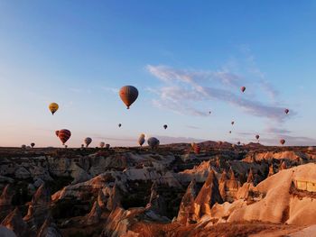 Hot air balloons flying over rocks