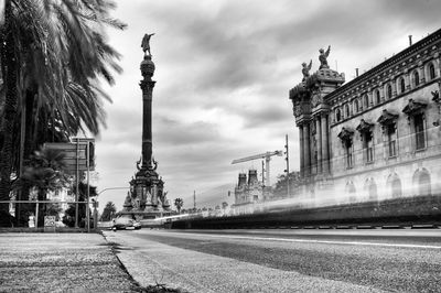 Statue in city against sky