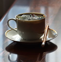 Close-up of paper clips in cup on table