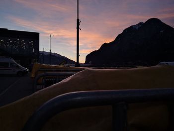 Road by mountains against sky during sunset