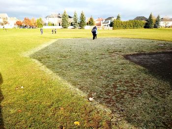 Rear view of man on field against sky