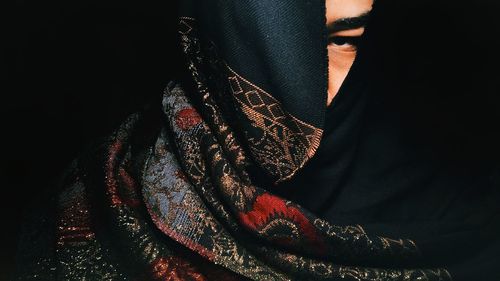 Close-up of woman against black background