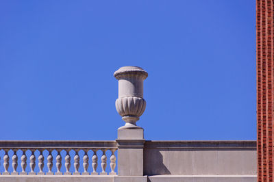 Low angle view of street light against building against clear blue sky