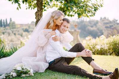 Cheerful couple embracing while sitting outdoors