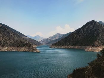 Scenic view of sea and mountains against sky