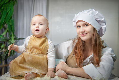 Portrait of smiling mother and daughter at home