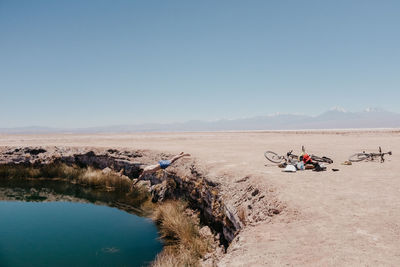 Shirtless man jumping in lake at desert