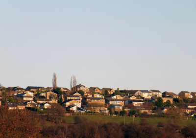 Houses on field against clear sky