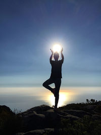 Silhouette woman standing by sea against sky during sunset