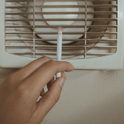 Close-up of hand holding cigarette