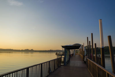 Pier over sea against sky during sunset