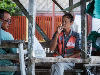 Low angle view of a man sitting on mobile phone