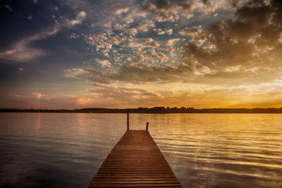 Pier on lake at sunset