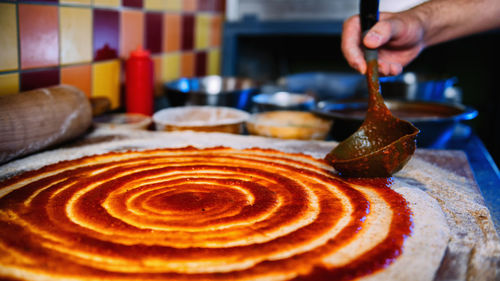 Close-up of man preparing pizza in kitchen at restaurant