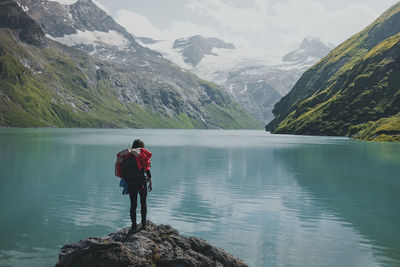 Rear view of woman standing by lake