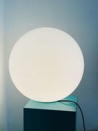 Close-up of electric lamp against white wall