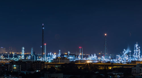 Illuminated buildings against sky at night