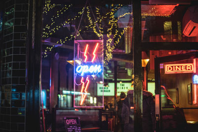 Illuminated open sign on restaurant at night