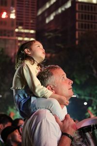 Full length of a father with daughter against blurred background