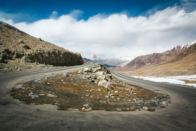 Road by mountain against sky