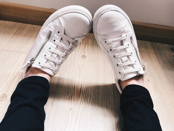 Low section of people wearing shoes on hardwood floor