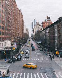 Traffic on road amidst buildings in city