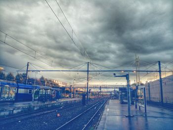 Railway tracks against cloudy sky