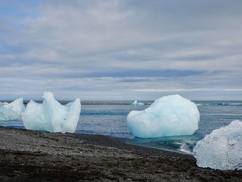 Frozen sea against sky during winter