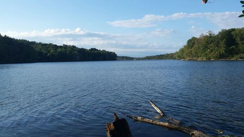 Scenic view of river against cloudy sky