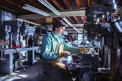 Worker operating machine in workshop