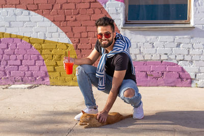 Full length portrait of young man against wall