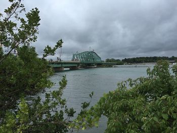 Scenic view of river against cloudy sky