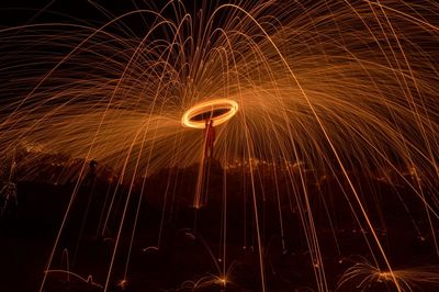 Man spinning wire wool at night