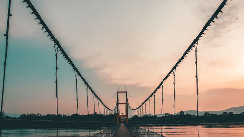 View of suspension bridge against sky during sunset