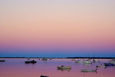 Boats in sea at sunset