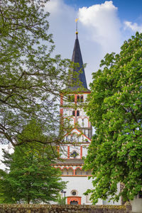 Low angle view of trees and building against sky