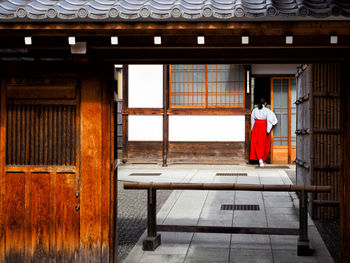 Rear view of woman looking at red building