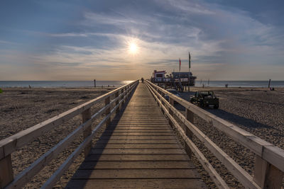 Footbridge on beach against sky