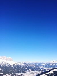 Scenic view of snowcapped mountains against clear blue sky